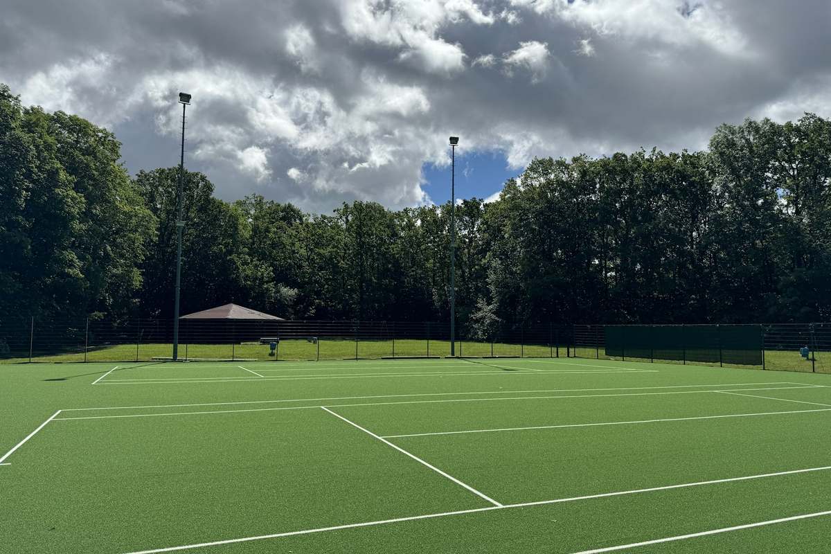 Pickleball court on an apartment grounds surrounded by mature trees