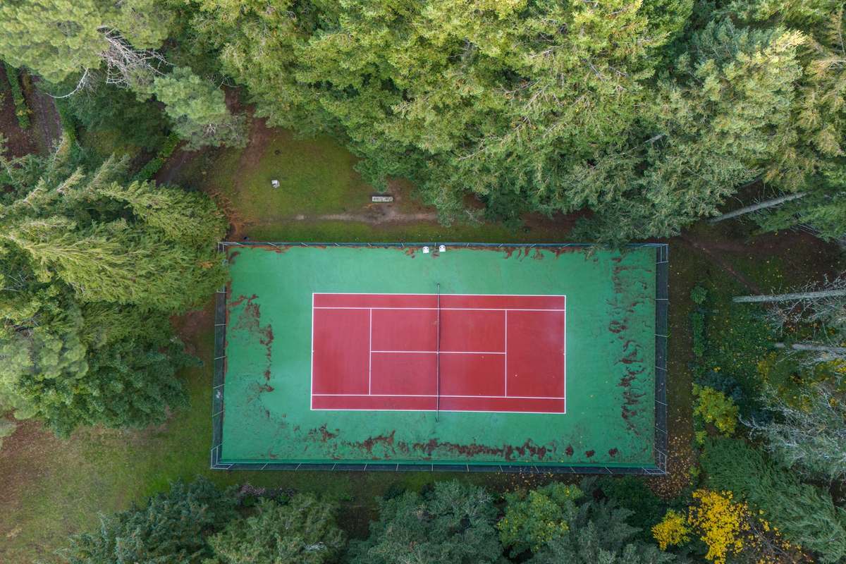 Aerial view of community pickleball courts among trees with walkways