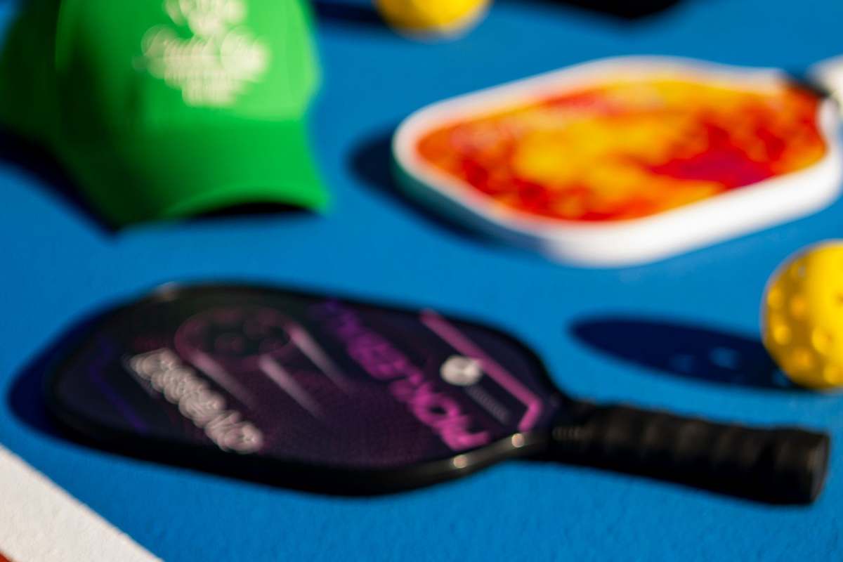 Pickleball paddles and balls on a marked court surface with white lines