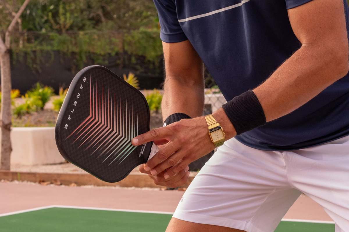 Guest playing pickleball on an outdoor court in daylight