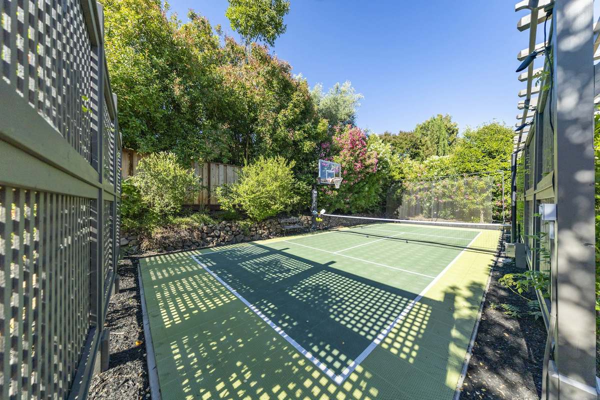 Private pickleball court on a garden lawn surrounded by trees